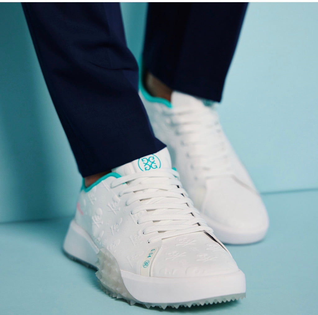 man wearing white g fore golf shoes with skull and tees embossed