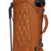 Close-up of a tan leather Titleist LINKSLEGEND Classic Members II Golf Stand Bag with quilted diamond stitching on the front panel, black hardware, a top carry handle, and part of a metal golf club shaft visible on the left.