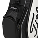 Close-up of a Titleist Tour Series Tour Golf Bag II in black and white, showing quilted black panels, a front zip pocket, and white script branding on a clean white background.