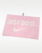 Nike Performance Golf Towel 2.0 in pink featuring a white Just Do It slogan, Swoosh logo, and a black attachment clip.