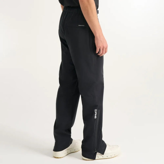Side view of black PING AquaDrive Pro waterproof golf trousers featuring a zipped leg hem and branded detailing.
