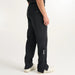 Side view of black PING AquaDrive Pro waterproof golf trousers featuring a zipped leg hem and branded detailing.