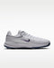Nike Victory Pro 4 golf shoes in white with a purple swoosh, side view featuring a spiked blue sole.