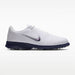 Nike Victory Tour 4 golf shoes in white and midnight navy, side view featuring a sleek leather design and spiked sole.