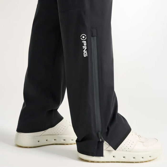 PING AquaDrive Pro black waterproof golf over trousers showing side leg zip detail and branding.