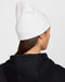 Back view of a white Nike Peak Futura unisex ribbed knit beanie worn on a person.