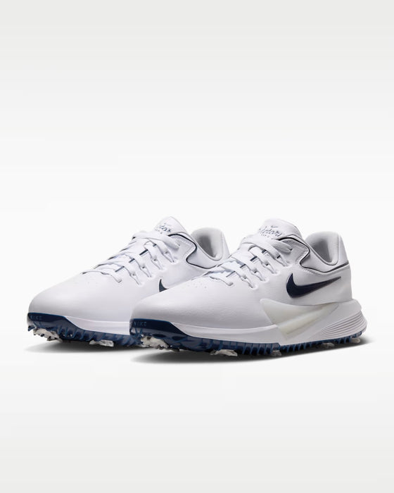 Nike Victory Pro 4 golf shoes in white with navy blue swoosh, featuring a sleek synthetic upper and spiked sole.