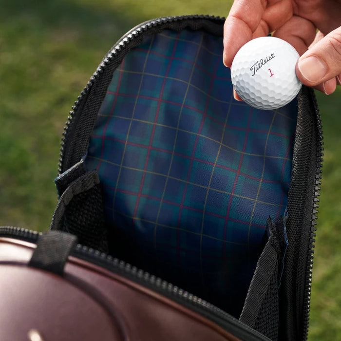 Titleist LINKSLEGEND golf bag pocket with blue tartan lining and a hand holding a white Titleist golf ball.