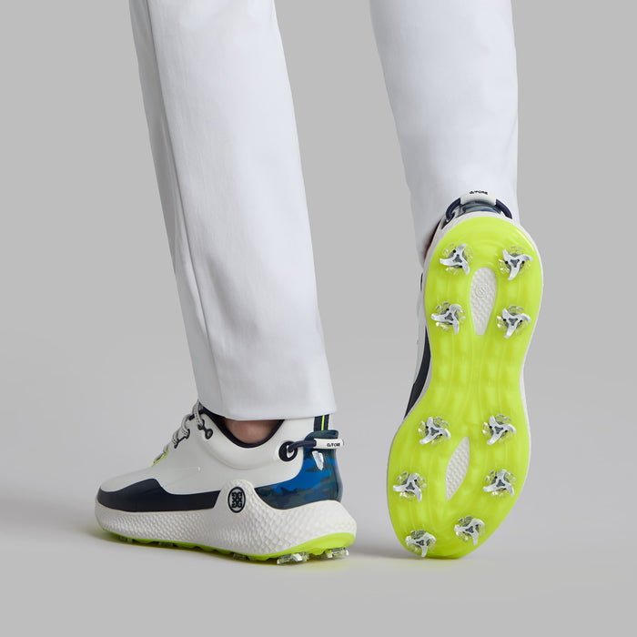 G/FORE MG4+ O2 G/LOCK Men's Golf Shoes in white and navy with lime green accents view of the shoes on a model who is raising one foot