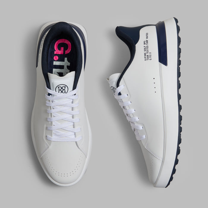G/FORE G.112 Spikeless Golf Shoes in white and navy, view of the pair with one shoe on its side