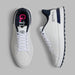 G/FORE G.112 Spikeless Golf Shoes in white and navy, view of the pair with one shoe on its side