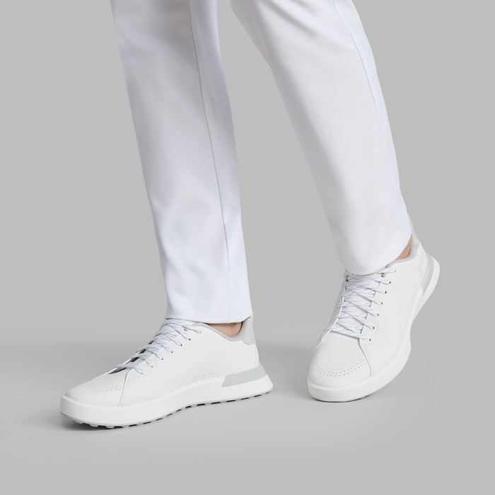 G/FORE G.112 Camo Spikeless Golf Shoes in white and grey on a model walking