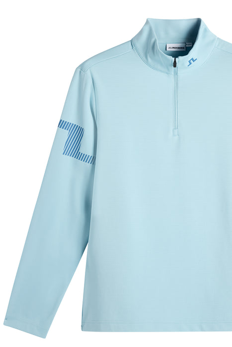 J.Lindeberg Heath Strike Quarter Zip Golf Mid Layer in light blue, close up of logo on sleeve