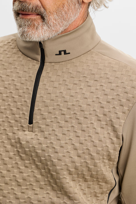 close up on male model of J.Lindeberg Lassy Quarter Zip Golf Mid Layer in beige