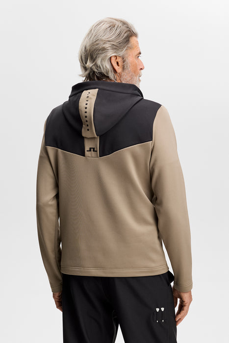 back of J.Lindeberg Maclean Quarter Zip Golf Hoodie in black and beige on a male model