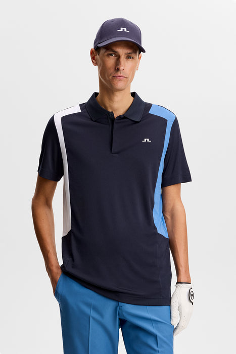 J.Lindeberg Legacy Golf Polo Shirt in navy with blue and white detail on model facing forwards showing front of shirt