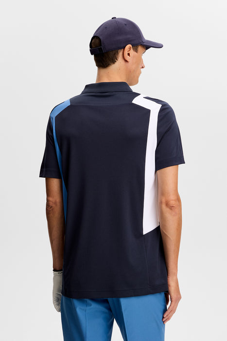 J.Lindeberg Legacy Golf Polo Shirt in navy on model, facing away showing back of golf shirt
