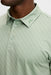 J.Lindeberg Tod Print Golf Polo Shirt in hedge green on a model, lose up of JL logo on collar