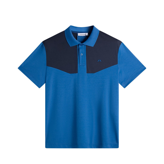 J.Lindeberg Calex golf polo shirt in Set Sail blue with a dark navy chest panel and button placket, front view.