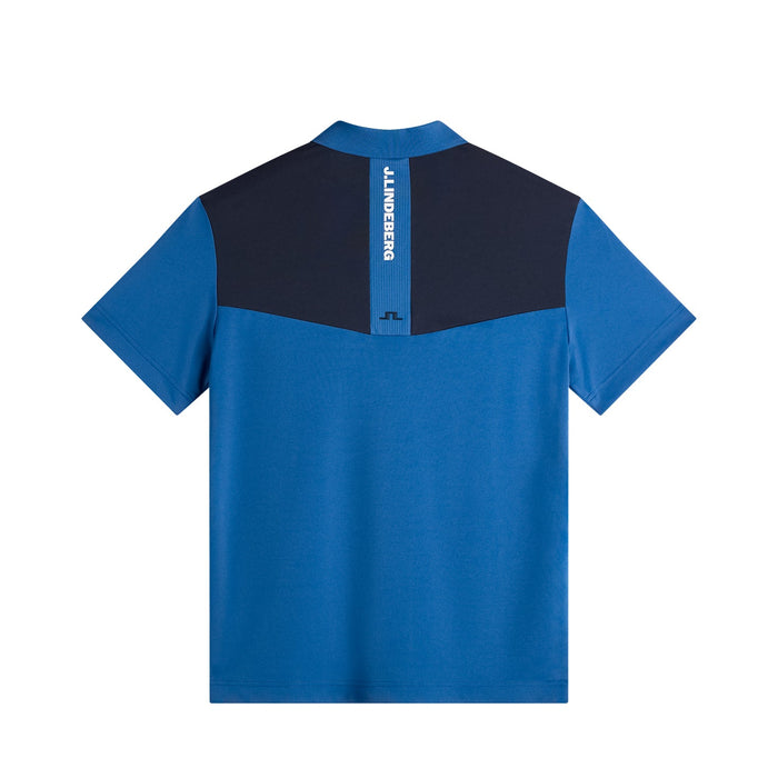 Back view of the blue and navy J.Lindeberg Calex golf polo shirt featuring a branded vertical stripe on the upper back.