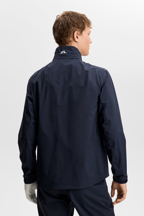 back of male model wearing J.Lindeberg Shay Rain Waterproof Golf Jacket in navy