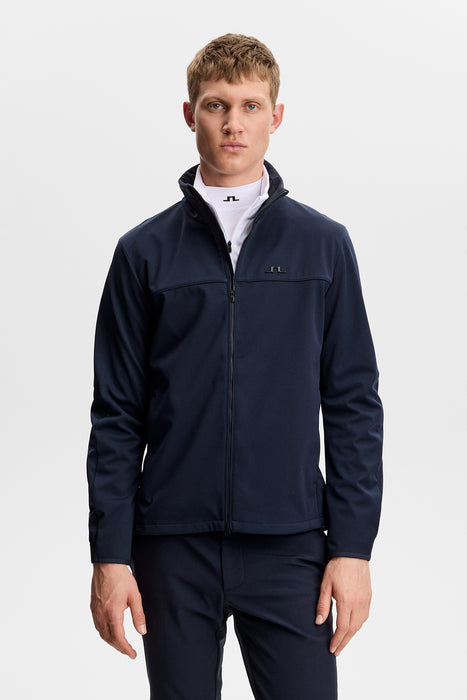 a male model wearing the J.Lindeberg Johnny Soft Shell Golf Jacket in navy