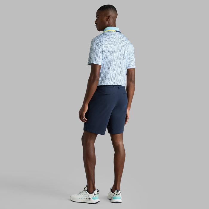 back profile of model wearing G/FORE Triple/G Tech Jersey Golf Polo Shirt in white blue and yellow