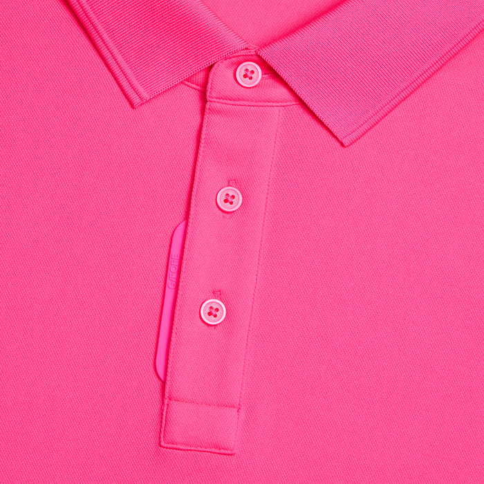 G/FORE Essential Performance Golf Pique Polo in knockout pick. close up of buttons and gfore tab