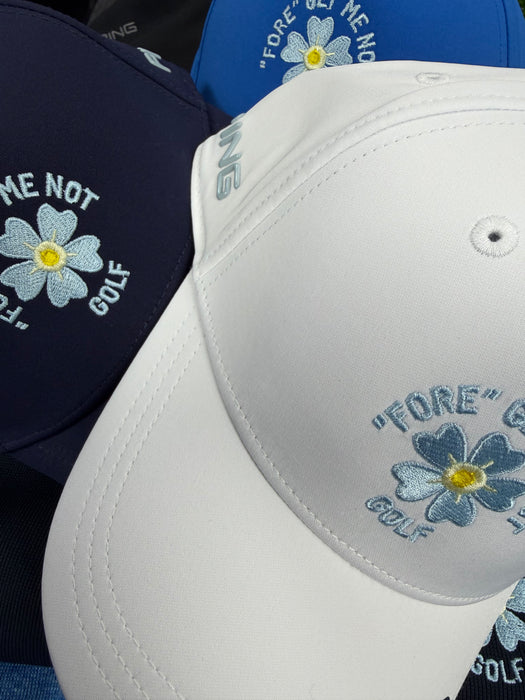 PING Fore Get Me Not golf hats in white, navy and blue with embroidered flower detail and PING branding.