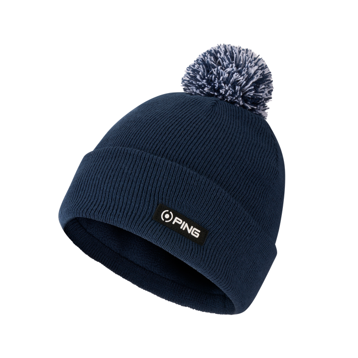 Navy blue PING ribbed knit winter hat with a matching blue and white pom-pom and branded front patch.