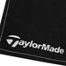 Taylormade Black Tour Golf Towel.Close up of one of the taylormade logos