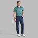 G/FORE Triple/G Tech Jersey Golf Polo Shirt in navy and green on model wearing navy trousers and white gfore golf shoes