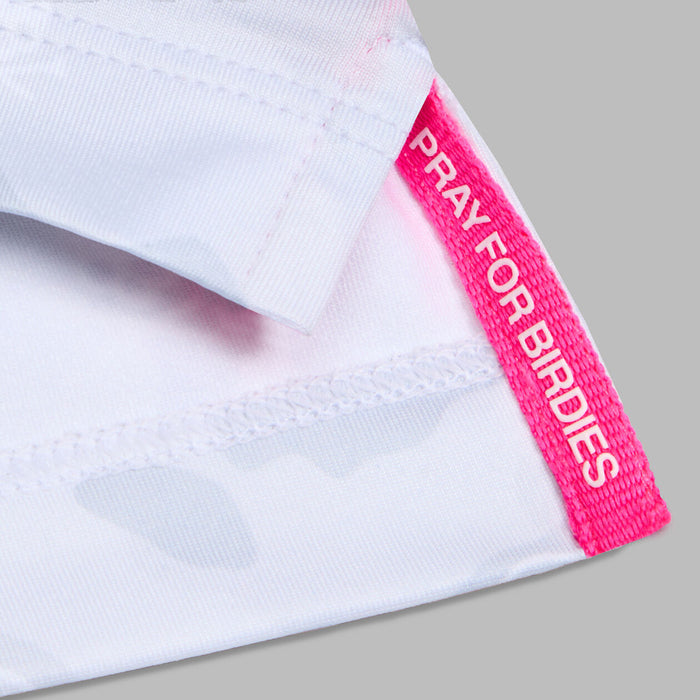 G/FORE Icon Camo Tech Jersey Golf Polo Shirt in white, close up of the pink hem