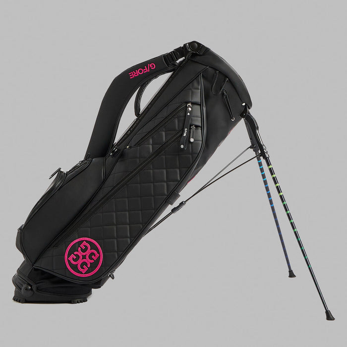 Side profile of G/FORE Daytona Plus Golf Stand Bag on its stand in black with pink