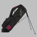 Side profile of G/FORE Daytona Plus Golf Stand Bag on its stand in black with pink