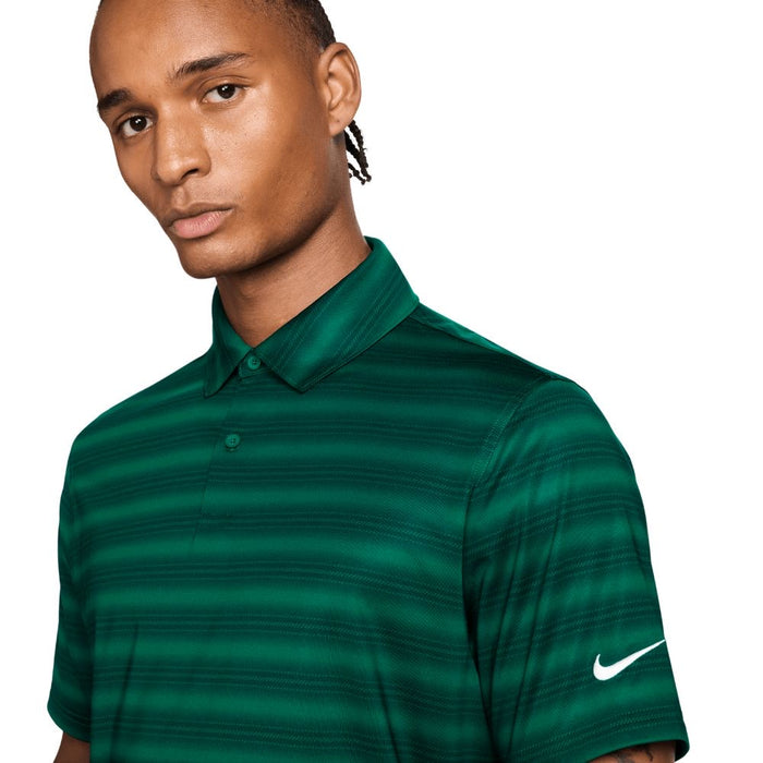 Man wearing a green striped polo shirt with a Nike logo on a white background