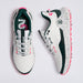 A pair of G/FORE MG4+ O2 G/LOCK Perforated Men's Golf Shoes shown from top and side views on a light grey background. The shoes are primarily white with dark green panels, a speckled white midsole, white laces, and bright pink accents on the tongue, collar, and outsole.