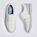 A pair of white G/FORE Gallivanter Leather Brogue Men's Spikeless Golf Shoes shown from the top and side views on a light grey background. The shoes feature perforated detailing on the toe, white laces, and a light grey sole with a textured tread.