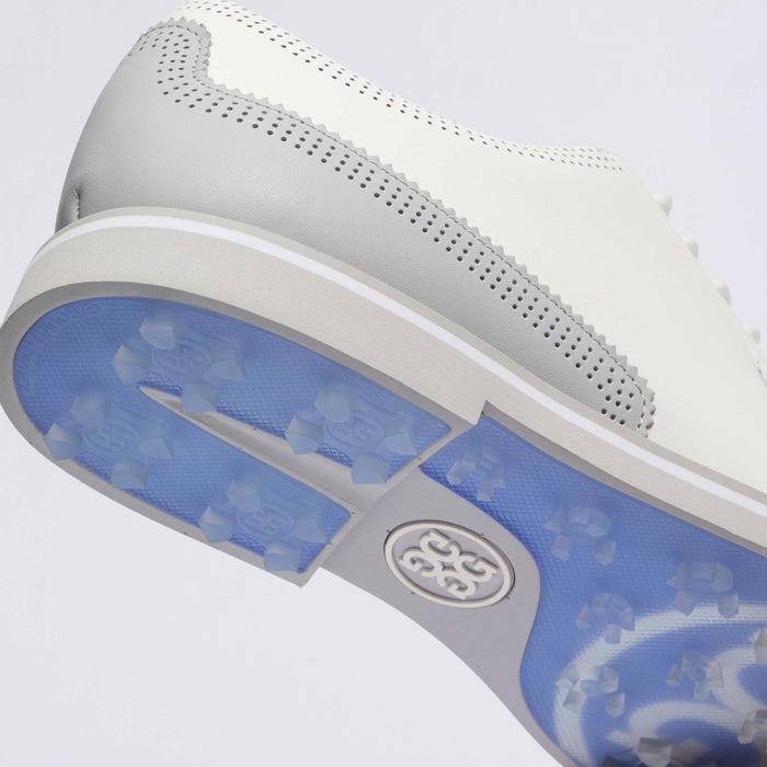 Close-up of a G/FORE Gallivanter Leather Brogue Men's Spikeless Golf Shoes sole showing a white leather upper with perforations, a white midsole, and a blue translucent golf sole with a visible Gfore logo.