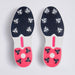 A pair of G/FORE Gallivan2R Brogue Saddle Men's Golf Shoes soles viewed from above, featuring a dark navy blue textured upper section with white and clear spikes, and a bright pink lower section with black and clear spikes, separated by a white midsole with a pink accent.