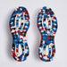 A pair of G/FORE MG4+ O2 Perforated Men's Spikeless Golf Shoes shown from the sole view, featuring a bold, geometric pattern in blue, red, black, and white with the brand name G/FORE printed vertically.