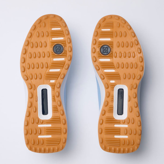 Top-down view of a pair of aG/FORE G.112 Perforated Men's Spikeless Golf Shoes showing their tan and white outsoles against a light white background.