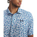 Under Armour Playoff 3.0 Printed Polo Golf Shirt in white, blue floral pattern on model, close up of logo