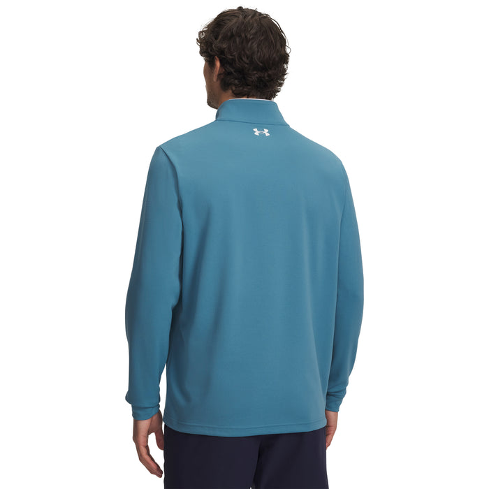 Person wearing a blue under armour golf midlayer with a brand logo on the back, on a white background