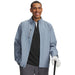 Under Armour Drive Pro waterproof golf jacket in blue wind with a front zip and high collar, worn by a smiling golfer.