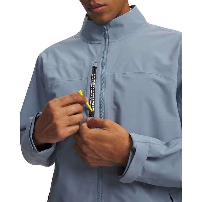 Under Armour Drive Pro waterproof golf jacket in light blue with a front zip pocket and branded trim detail.
