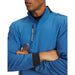 Blue Under Armour Drive Pro Hybrid golf midlayer with half-zip, textured sleeves, and black collar, front view.
