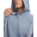 Under Armour Drive men's golf hoodie in light blue with a textured finish and small chest logo, close-up view.